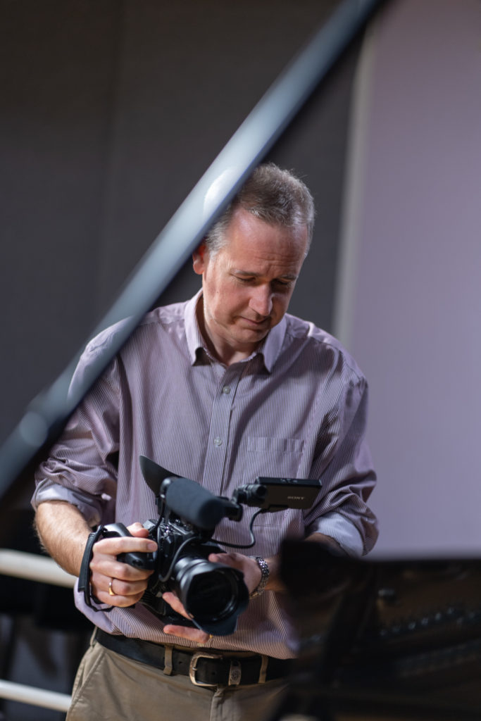 Martin Phillips with camera filming a piano at the Royal College of Music.